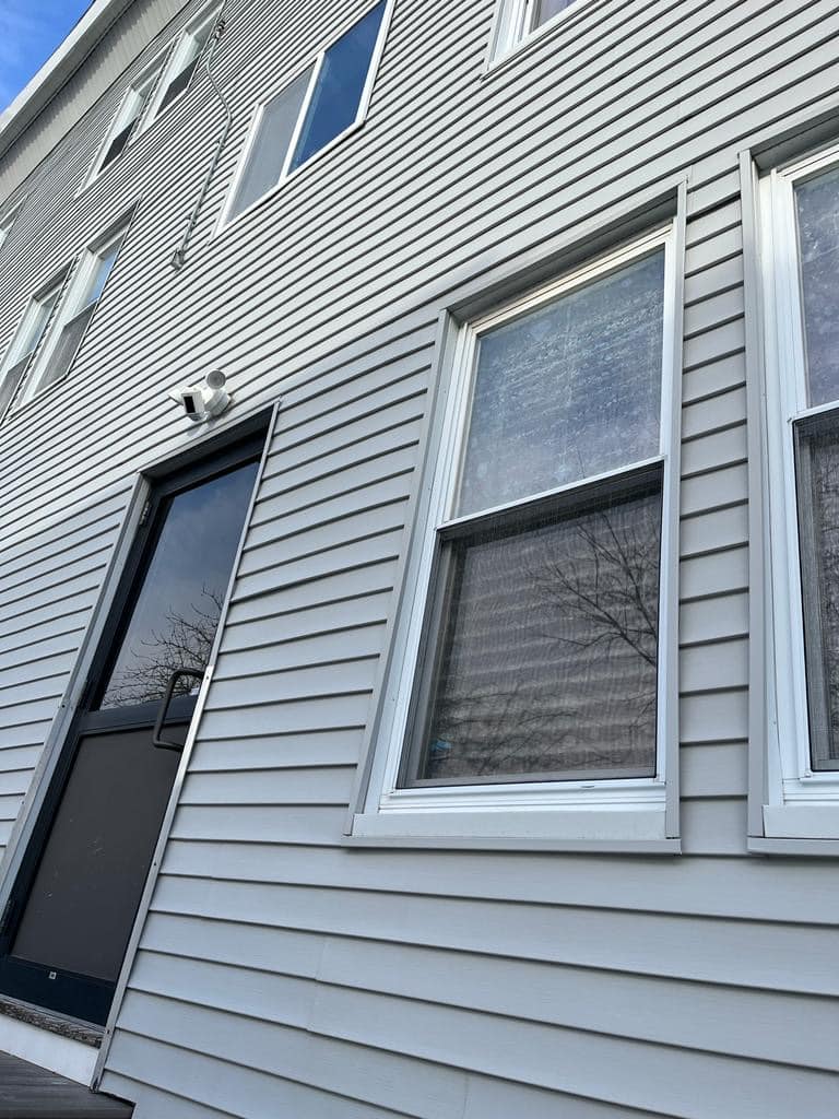 2024-01-19 16 33 32Z-lrkv13oojs9grvhj light gray vinyl siding with a black storm door and windows.
