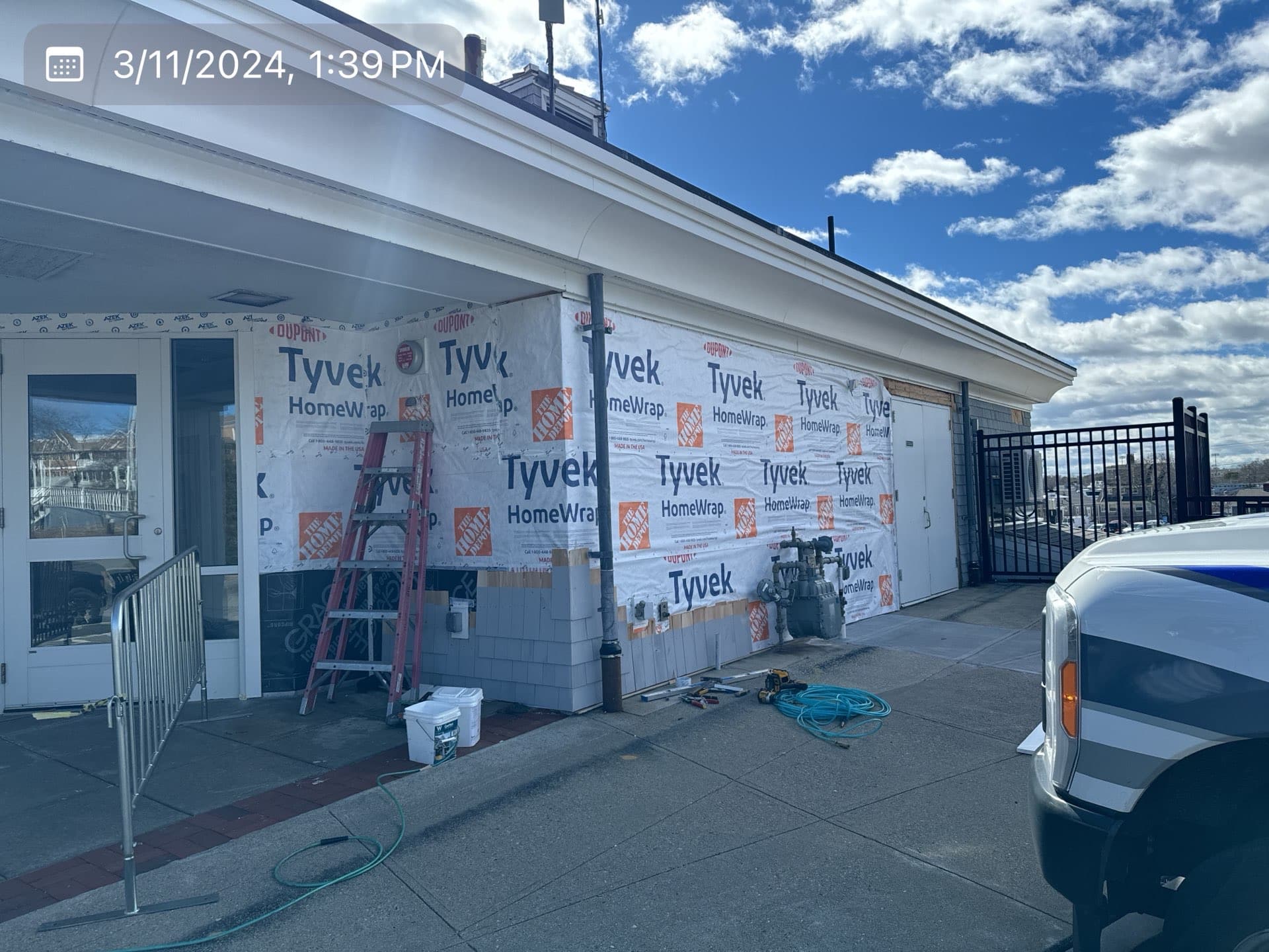 2024-03-11 17 39 38Z-ltn8aeilqerz4up0 Building exterior wrapped in Tyvek house wrap during siding installation.