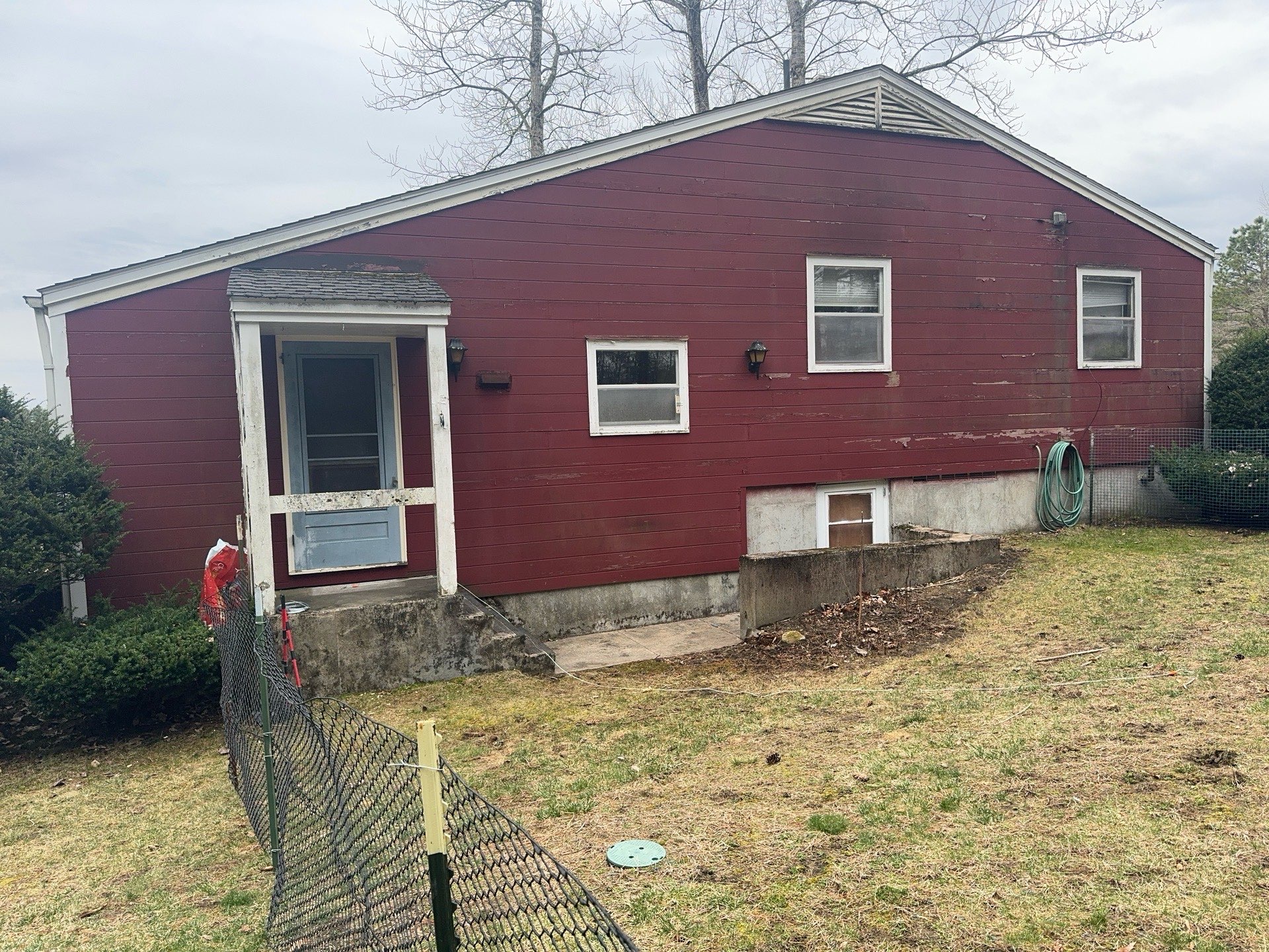 2024-04-02 13 28 12Z-luiezt2fh8oee82c Backyard view of a red house with a screened porch and a sparse lawn.