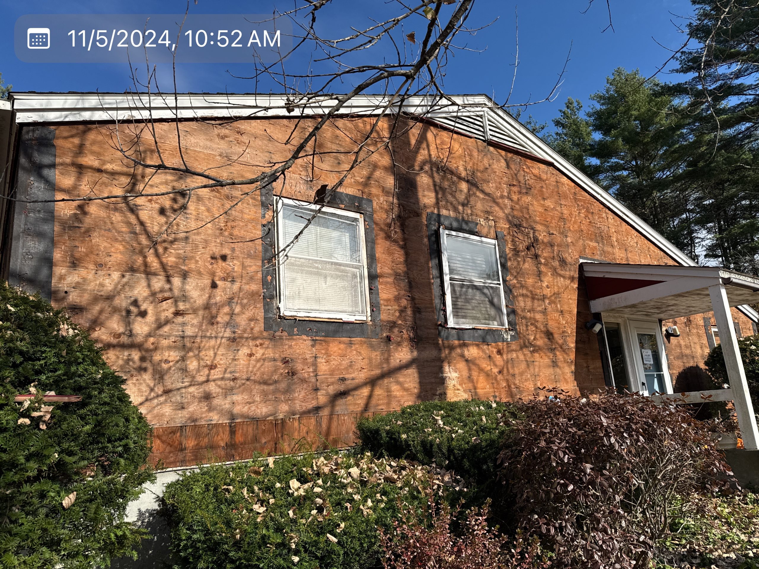 2024-11-05 15 52 57Z-m34mpt9w7rn98zrq Red brick house with white trim, small porch, and front steps under a clear blue sky.