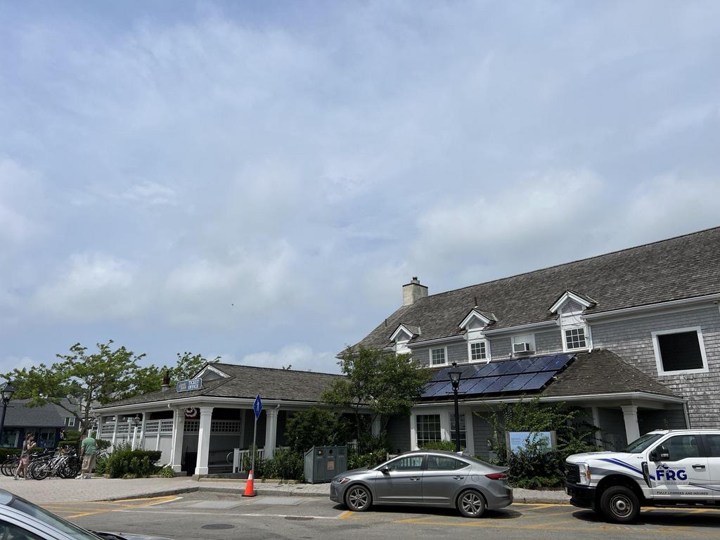 7 28 2023 16 51 19-lkn26jscjahx209c Gray shingle building complex with solar panels on the roof and a contractor truck.