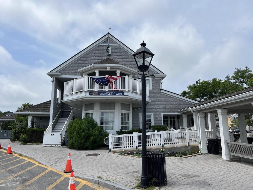 7 28 2023 16 51 19-lkn26jskyluapekk Gray shingle building with a white balcony and American flag decoration.