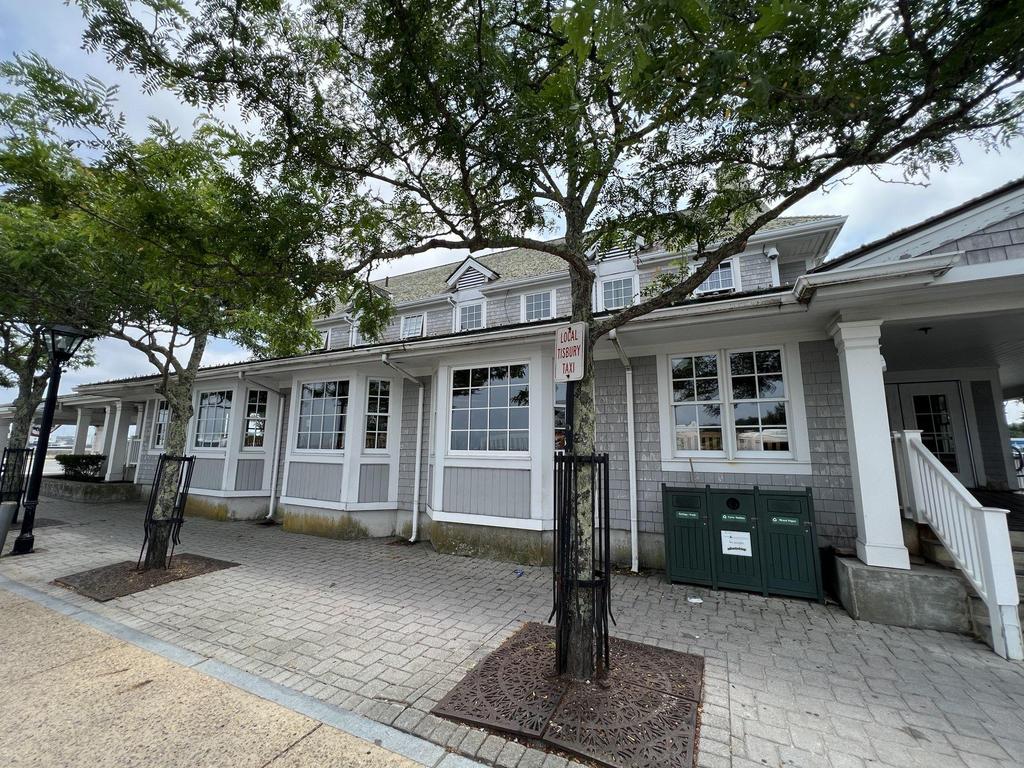 7 28 2023 16 51 19-lkn26jsviqyho9yv Gray shingle building with many white windows under trees.