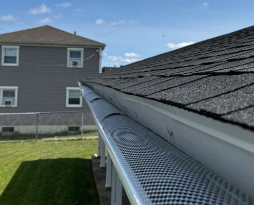 A wide-angle view of a residential roofline featuring a seamless Gutter Guard installation to ensure long-term drainage protection.